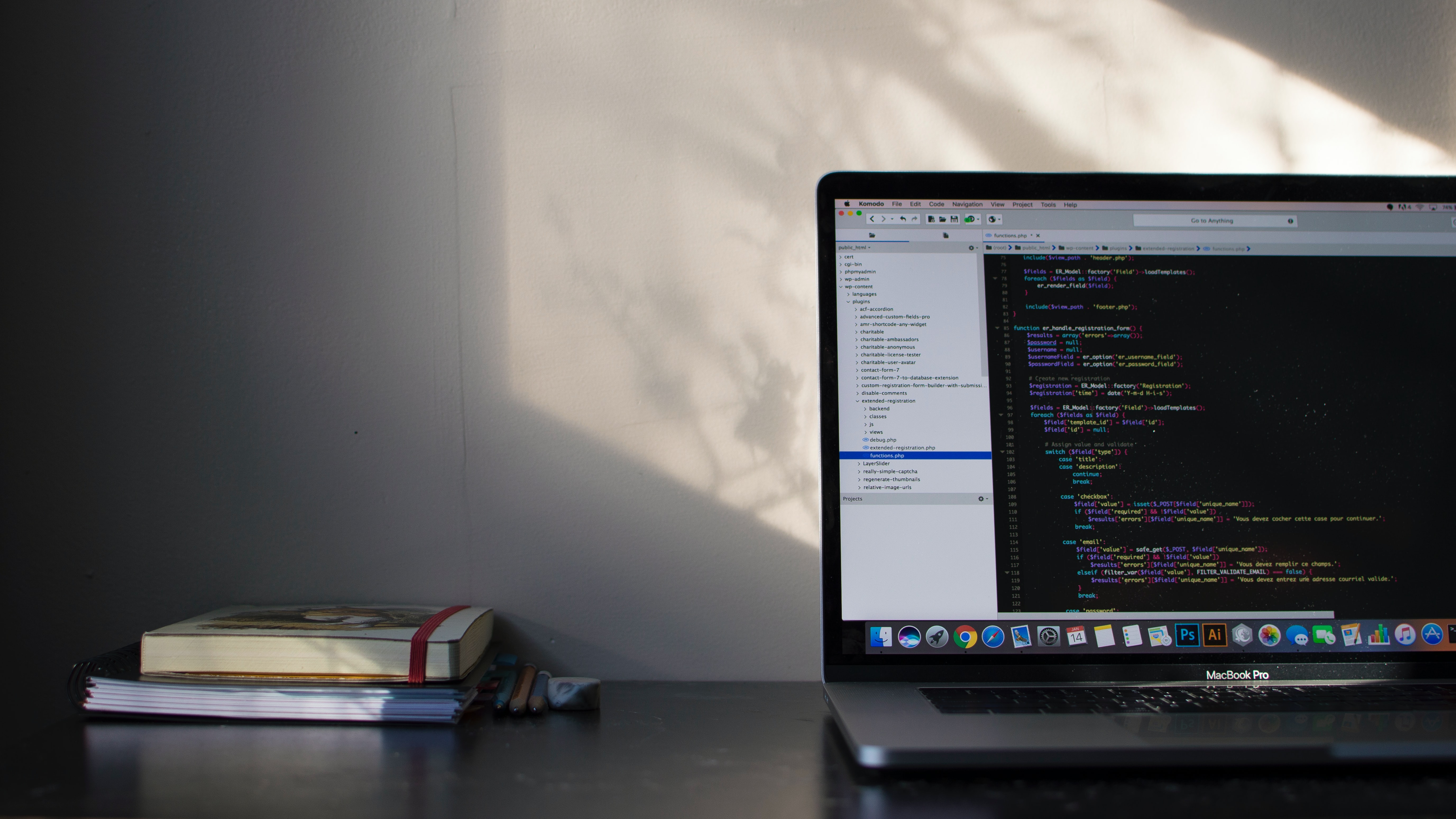 laptop sits on a desk with a coding screen