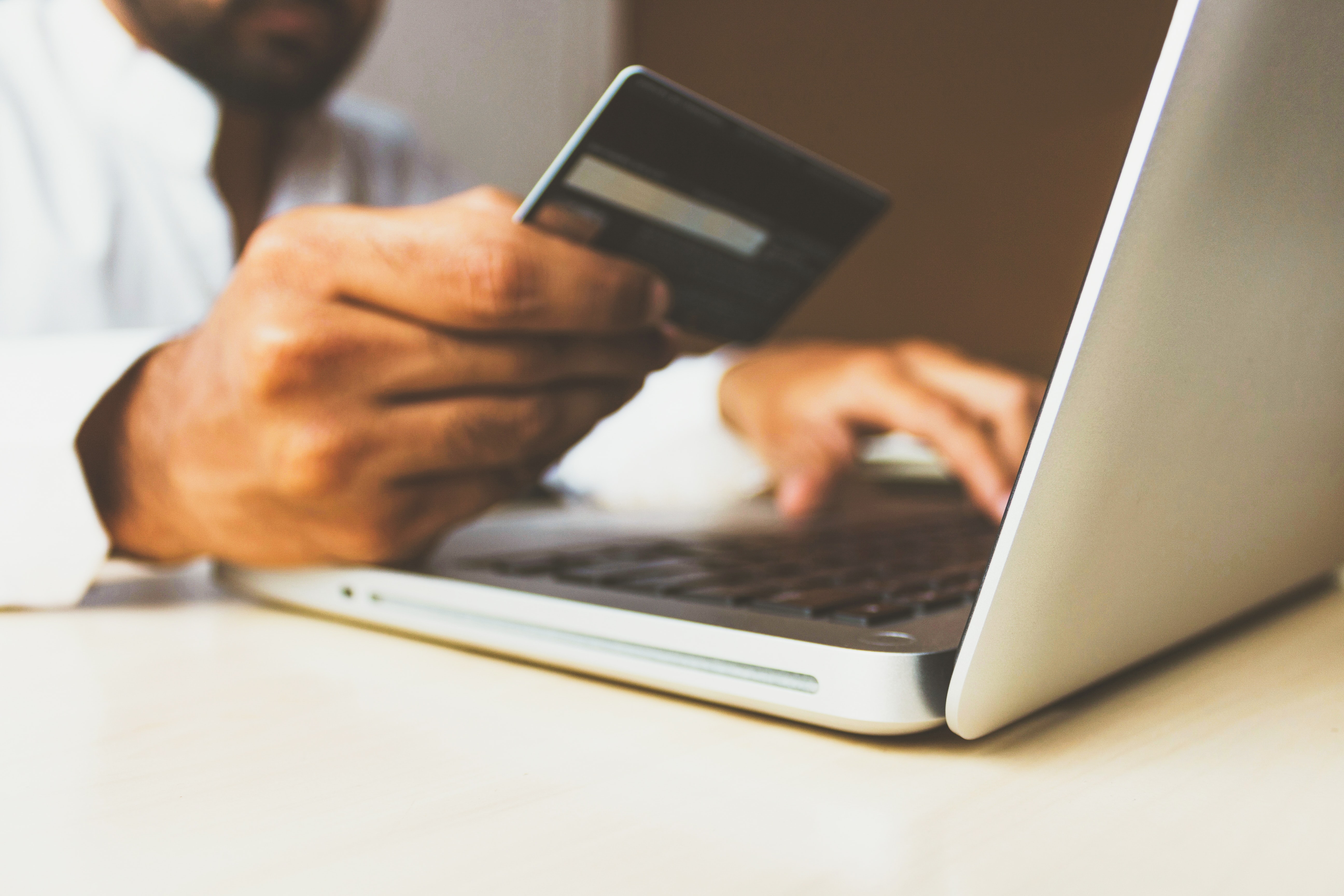 man goes to purchase item on the internet holding his card